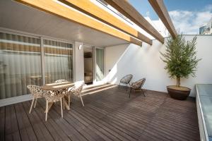 a deck with a table and chairs and a potted plant at MAM HEAT Apartments - Viana City Centre in Viana do Castelo