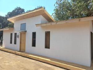 a small white house with a door on it at Cabaña en La Laguna in Valparaíso