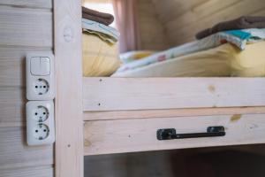 une armoire en bois avec une porte ouverte et un lit dans l'établissement Natur Camp Birštonas Small Cabins, à Birštonas