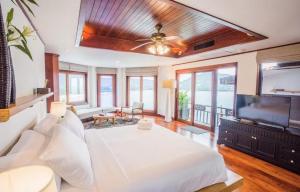 a bedroom with a large white bed and a flat screen tv at Lang- Villa Amara，Kamala beach luxury villa in Surin Beach