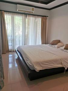 een slaapkamer met een groot bed voor de ramen bij DD Condominium in Ban Khlong Mae Nam