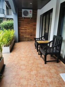 een patio met 2 banken, een tafel en een ventilator bij DD Condominium in Ban Khlong Mae Nam