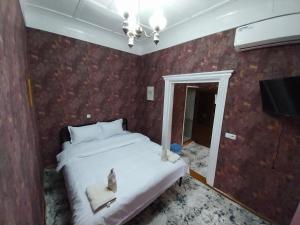 um quarto com uma cama e um lustre em Fayz Guest House em Samarkand