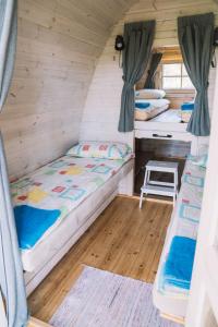 Cette chambre comprend deux lits et un bureau. dans l'établissement Natur Camp Birštonas Small Cabins, à Birštonas