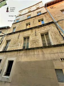 um edifício de tijolos alto com janelas em cima em Le Colibri, Duplex Lumineux Intramuros em Avignon