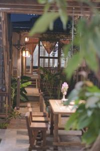 a wooden porch with a table and benches on it at Thoai Mai House Phan Thiết in Ấp Bình Hưng