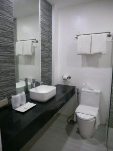 ein weißes Bad mit einem Waschbecken und einem WC in der Unterkunft Hava Resort Calatagan 
