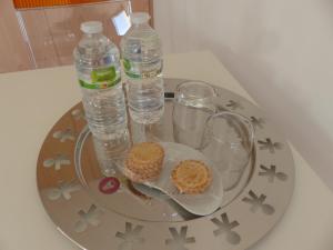 een dienblad met twee flessen water en koekjes erop bij Les Chambres d'hôtes de Kérasquer in Lannilis