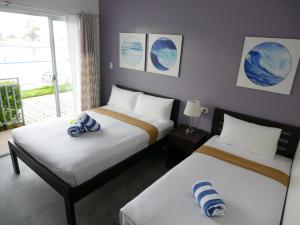 1 Schlafzimmer mit 2 Betten und einem Fenster in der Unterkunft Hava Resort Calatagan 