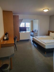 una camera d'albergo con letto e soggiorno di Hotel Sonne a Seiffen