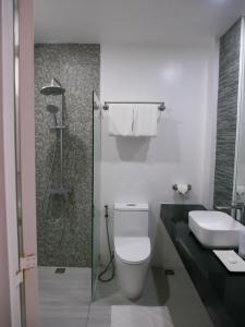 ein Bad mit einer Dusche, einem WC und einem Waschbecken in der Unterkunft Hava Resort Calatagan 
