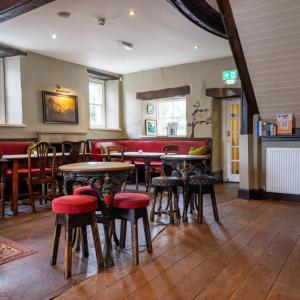 un restaurante con mesas y sillas y un bar en The Derby Arms Witherslack, en Grange-over-Sands