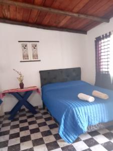 a bedroom with a blue bed and a table at Mí Santa Guadalupe Esquina ctes in Esquina