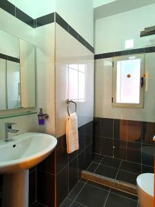een badkamer met een wastafel en een douche bij Melissa Apartments in Sarandë
