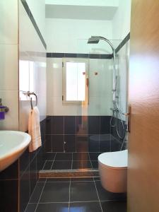 een badkamer met een douche, een toilet en een wastafel bij Melissa Apartments in Sarandë