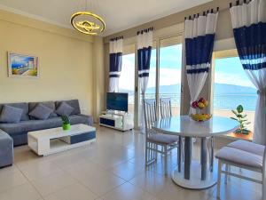 een woonkamer met een bank en een tafel met stoelen bij Melissa Apartments in Sarandë