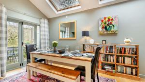 a dining room with a table and a book shelf at Hillcrest Barn in Monyash