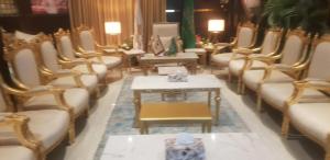 a row of chairs and tables in a room at ليالي العاذريه للشقق المخدومة in Al Namas