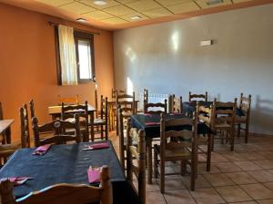 Hotel el Cid في Torres de Albarracín: غرفة طعام مع طاولات وكراسي في غرفة