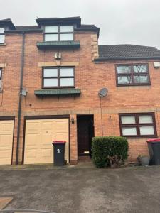 a brick house with two sets of garage doors at *RARE FIND* 3 story, 2 bedroom house in Coleshill