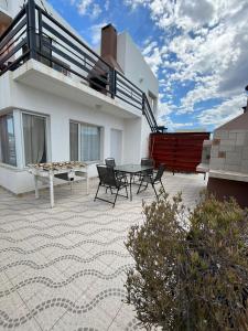 un patio con tavolo e sedie in una casa di Altas Mareas a Las Grutas
