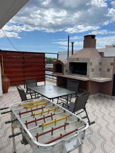 a patio with a table and chairs and a grill at Altas Mareas in Las Grutas