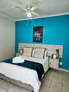 ein Schlafzimmer mit einer blauen Wand und einem Bett in der Unterkunft Sea Breeze Manor - Aqua Unit in East London