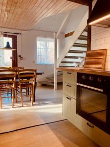 a kitchen and dining room with a staircase and a table at Lunkaberg Bed & Breakfast in Simrishamn