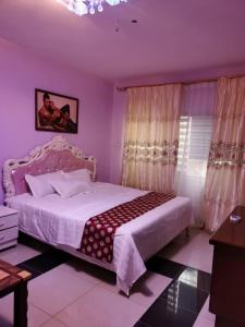 - une chambre avec un grand lit aux murs violets dans l'établissement hongyuanprimierhotel, à Accra