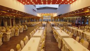 einen großen Bankettsaal mit weißen Tischen und Stühlen in der Unterkunft Truva Life Hotel in Samandağı
