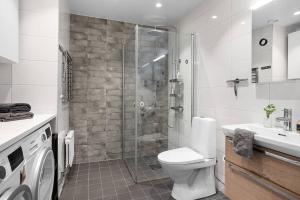 a bathroom with a shower and a toilet and a sink at Tranquil and Convenience Southern Malmo Apartment in Malmö