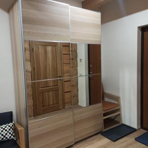 a room with a glass closet with a wooden door at S Neries 19 apartamentai su parkingu in Šiauliai