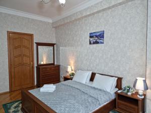 a bedroom with a bed and two night stands and a door at Mayden Family Apartment in Baku