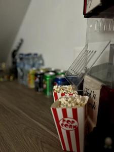 two bags of popcorn sitting next to a box of soda at Escapade Cinéma : Duplex 50m² in Linas