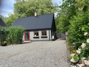 a house with a black roof and a gravel driveway at Hannas guesthouse 