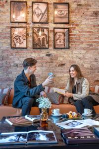 un hombre y una mujer sentados alrededor de una mesa en SERHS Carlit Boutique Hotel, en Barcelona