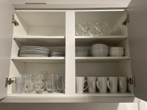 a white cabinet filled with dishes and glasses at Dinorwic Lodge in Liverpool