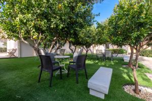 a patio with tables and chairs under orange trees at Tinas Village Free Transport from/to the airport in Spáta