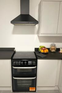 a kitchen with a stove and a bowl of fruit on a counter at Dinorwic Lodge in Liverpool