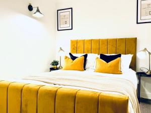 a bedroom with a large bed with yellow pillows at Rooms Near Me - Central Birmingham Free Parking in Birmingham