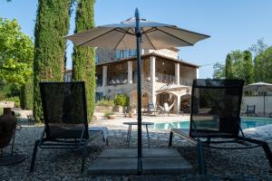 a table and two chairs with an umbrella next to a pool at Gîte Le Bel Endroit in Saint-André-de-Cruzières +54 photos