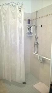 eine Dusche mit einem weißen Duschvorhang im Bad in der Unterkunft Agriturismo La Cantina in Bastia Umbra