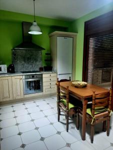 cocina con mesa de madera y paredes verdes en Casa Cotis Beceite, en Beceite