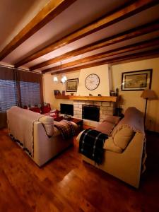sala de estar con 2 sofás y chimenea en Casa Cotis Beceite en Beceite