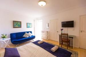 a living room with a blue couch and a blue couch at Ocean Breeze Bloubergstrand in Bloubergstrand