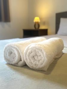 uma pilha de toalhas sentadas numa cama em Casa Jabuticaba a 5 min dos Thermas e Hot Beach em Olímpia