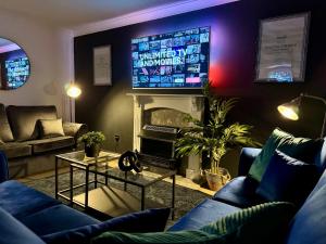 a living room with a fireplace and a tv at Rooms Near Me - Central Birmingham Free Parking in Birmingham