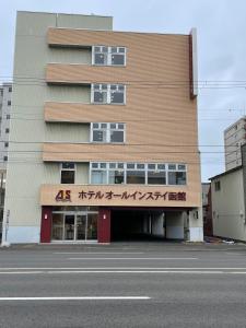 a building with writing on it next to a street at Hotel All In Stay Hakodate in Hakodate