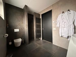 a bathroom with a white robe hanging on a wall at De Zilten Kaēmer Zoutelande in Zoutelande