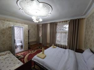 Un dormitorio con una cama grande y una lámpara de araña. en Fayz Guest House, en Samarkand